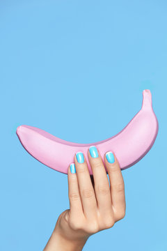 Nails Beauty. Hand With Blue Nails Holding Banana