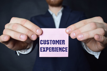 A businessman shows an inscription:CUSTOMER EXPERIENCE
