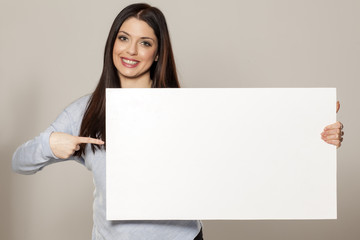 Happy woman showing empty blank paper card sign with copy space for text