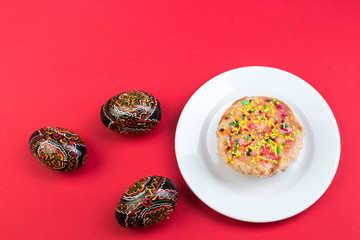 Happy Easter. Painted eggs on red background. Easter Cake - Russian and Ukrainian Traditional Kulich, Paska Easter Bread. Top view. Copy space for text.