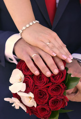 Obraz na płótnie Canvas the bride and groom hold hands on their wedding bouquet