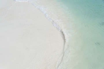 Fototapeta na wymiar closed up clear and blue wave of the sea on white beautiful island beach