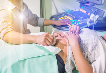 Close up obstetrician operating ultrasound scanner examining belly pregnant woman at the hospital...