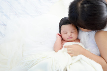 Older sister kissing her newborn.