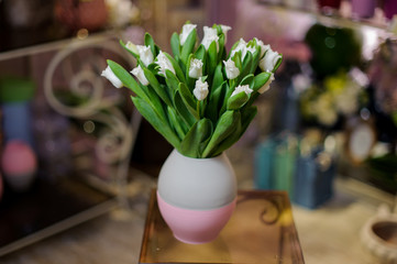 Beautiful white tulips standing in the blue and pink vase