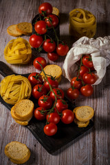 Small cherry tomatoes on several twigs with pasta