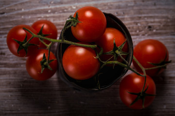 Top view on several cherry tomatoes on green twig in vintage metal can