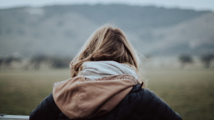 A close up shot of travel woman being outdoor surrounded by mountains looking far away