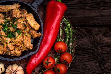 Fried pork in frying pan and vegetables