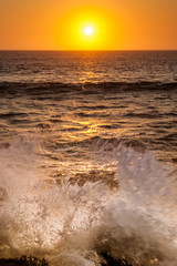 Fototapeta na wymiar Wave crashing at sunset