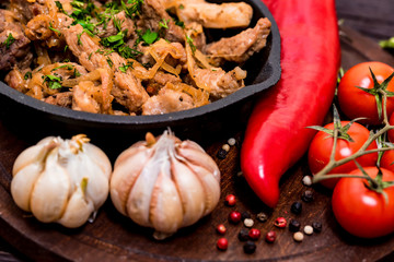 Fried pork in frying pan and vegetables