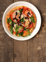 Tasty pizza with rucola on a rustic table