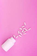 A bottle with pills on a pink background. Concept Medicine. Place for text.