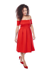 Beautiful curly female in red dress and red high heels shoes in full length