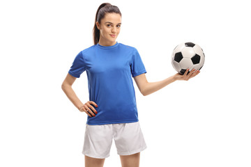 Female soccer player holding a football
