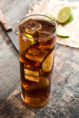 Cuba libre. Cocktail with rum, lime and ice on wooden table. 