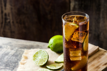 Cuba libre. Cocktail with rum, lime and ice on wooden table. Copyspace