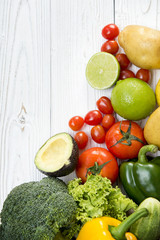 Fresh organic vegetables Include lime, tomato, avocado, sweet pepper, broccoli, potatoes on white wooden and copy space. Top view food healthy concept