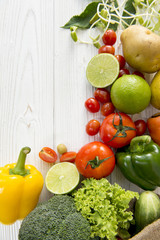 Fresh organic vegetables Include lime, tomato, avocado, sweet pepper, broccoli, potatoes on white wooden and copy space. Top view food healthy concept