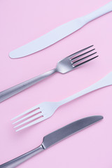 Knife and fork set on trendy soft pastel color paper background