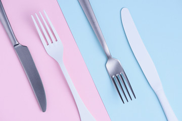 Knife and fork set on trendy soft pastel color paper background