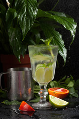 lemonade in a glass on a dark background. spray and motion