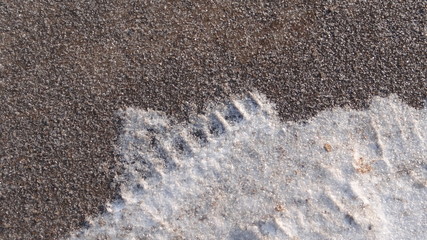 The texture of the asphalt and snow.