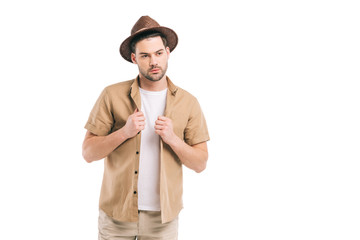 handsome bearded young man in hat and shirt looking away isolated on white