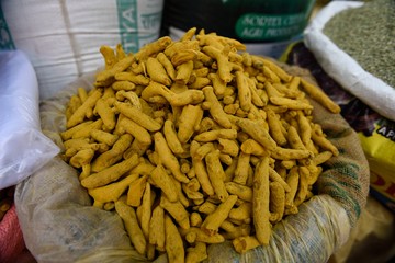 Basket of fresh raw dried Turmeric / Curcumin (Curcuma Longa) in a spice market, Jaipur, Rajasthan, India.	