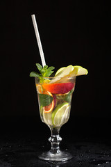 glass with iced vodka on black background