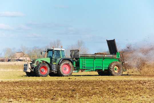 Tractor with manure spreader on the field - 1303