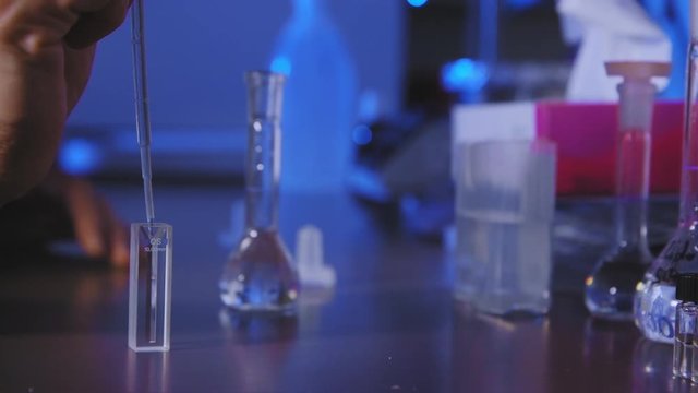 Scientist making an experiment. Filling a test tube in order to analyse fluids