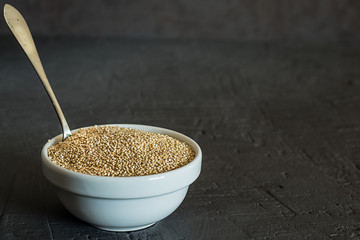 Quinoa seeds in a bowl and spoon