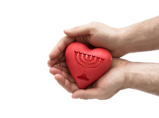 Red heart with imprinted menorah in man's hands.