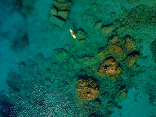 Aerial view of the paddle boat in the exotic turquoise coral sea.