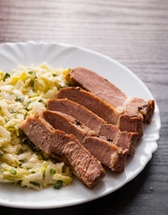 meat fillet with vegetables salad in a plate on wooden table