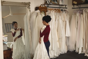Beautiful young bride with white wedding dress looking into mirror