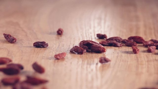 Goji Berries authentic Slow Motion falling on wooden table