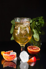 Fresh drink with ice and green lime on black background