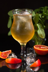 Fresh drink with ice and green lime on black background