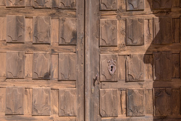 old wooden door and metal lock of facade exterior of church from thirteenth century, in Santa Maria de Riaza, next Ayllon town, Segovia, Castile, Spain, Europe
