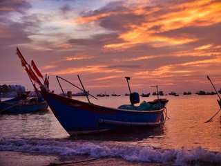 Old fishing boat in the sea at sunset