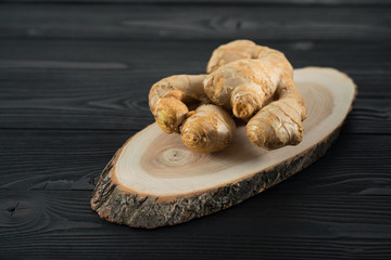 root of fresh ginger on a wooden background