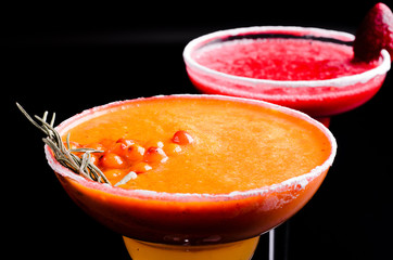 two classic and strawberry margarita, white and red alcoholic cocktail with decoration of salt on the edge of the glass with fresh lime, lemon, daiquiri on gray background restaurant. Bar alcohol menu