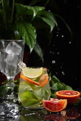 lemonade in a glass on a dark background. spray and motion