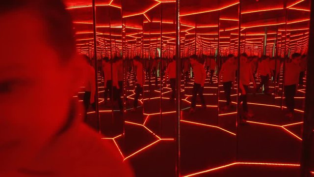 Boy playing with distorted mirror.