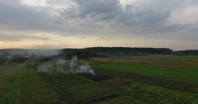 Flying a drone, Aerial view over agricultural fields where farmers burn fires, Central Europe, Ukraine