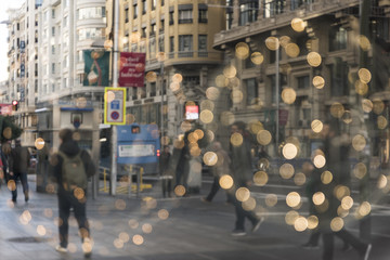 Abstract image of people walking along the Gran Vía of Madrid on a Christmas morning.