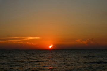 Obraz premium sunset last light on sky line dark little wave on sea