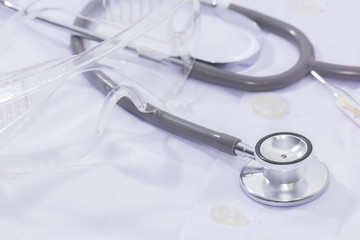 stethoscope and protection glass on white background